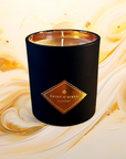 Black candle with a gold logo on a swirling yellow and white background