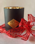 Saint O'Niell Alchemy's classic luxury scented candle in black matte vessel with gold metallic interior, wrapped in a sheer red dotted organza ribbon, can be purchased via. a Gift Card to allow your people to choose their preferred scent.